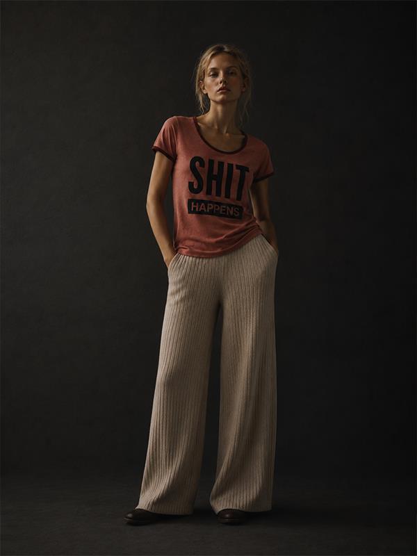 Esta remera entallada es de corte ajustado, confeccionada en un suave algodón en tono rosa pálido. Tiene cuello redondo y puños ribeteados en bordó, aportando contraste. 